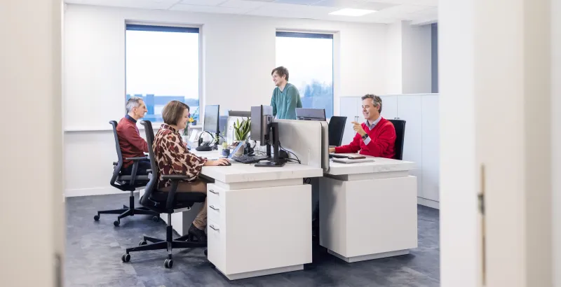 Office room with four people working at desk
